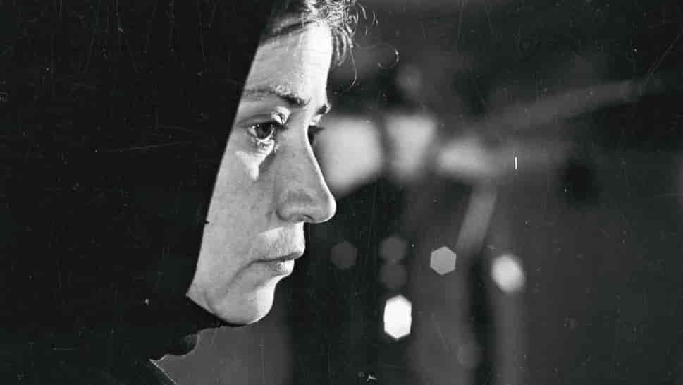 Black-and-white still from "Reconstruction" depicting a remote Greek village.